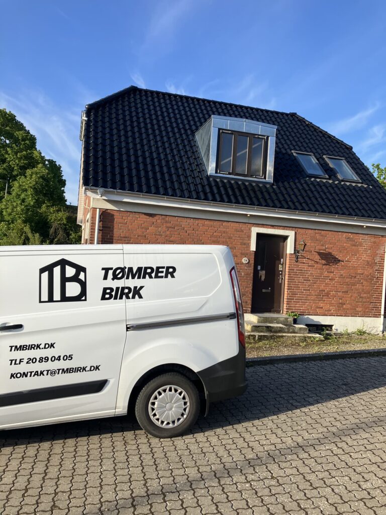 Tømrer Birks varebil foran et hus med nyt tag og kvist