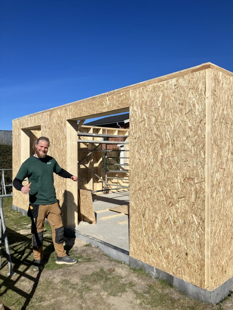 Hjalte foran en tilbygning i OSB under opbygning