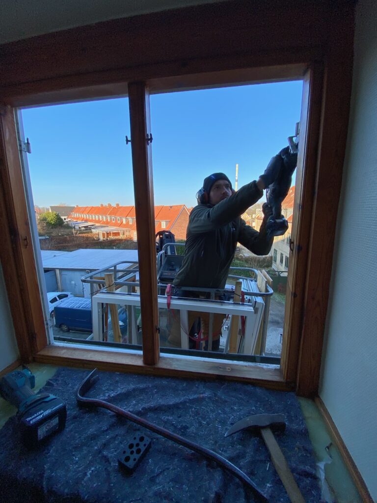 Tømrer monterer et nyt vindue indefra