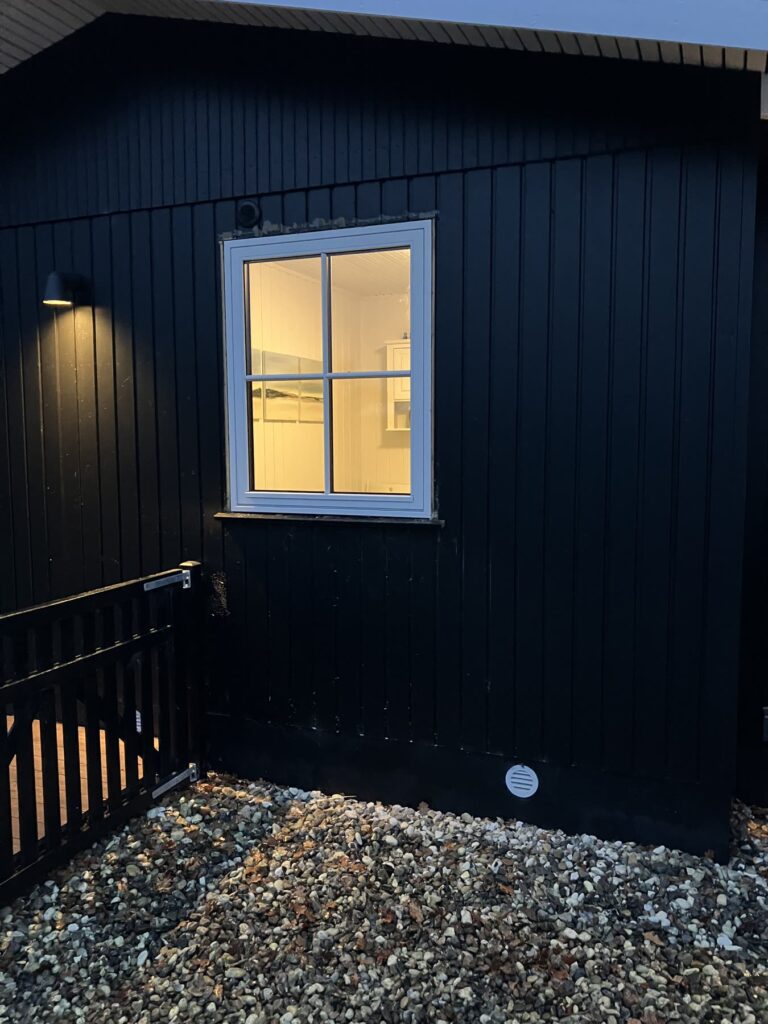 Nyt hvidt vindue i en sort træfacade